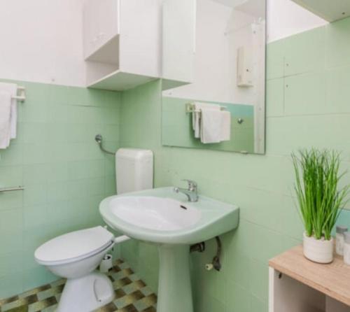 a bathroom with a white toilet and a sink at Nin Heritage Home in Nin