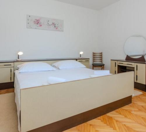 a large white bed in a room with a desk at Nin Heritage Home in Nin