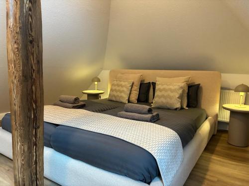 a large bed in a room with two tables at LYMA Suites - Apartment B44 in Immenstadt im Allgäu