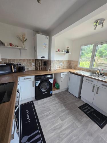 a kitchen with a washer and dryer in it at Spacious - Free Parking - Sleeps 6 - M20-FolkestoneCentralStation in Folkestone