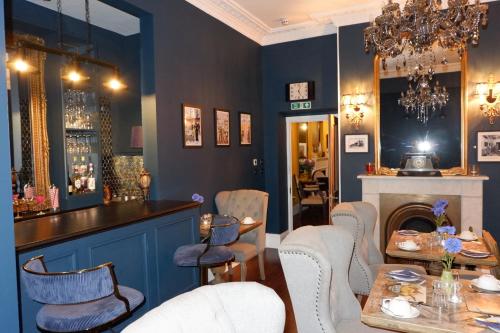 a restaurant with blue walls and a bar with chairs at Southbank Townhouse in Torquay