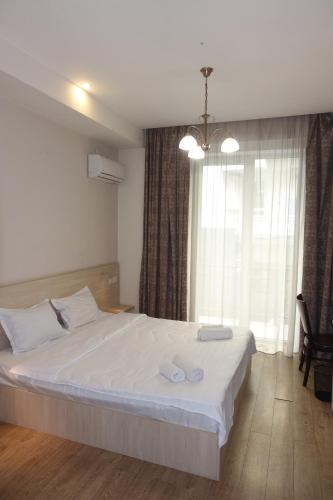 a bedroom with a large bed with two towels on it at Metekhi Stay - Old Tbilisi in Tbilisi City