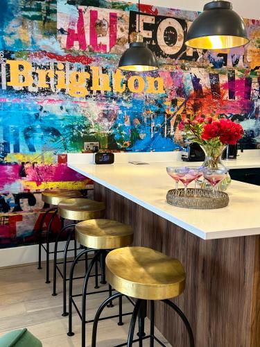 a bar with stools in front of a colorful wall at Mrs Butlers Stylish Mews House Central Brighton Great Prices in Brighton & Hove