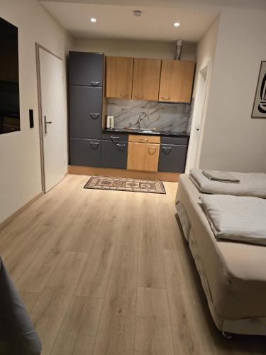 a room with a bed and a kitchen with wooden cabinets at Marlin City Apartment Erdgeschoss 1 in Bielefeld