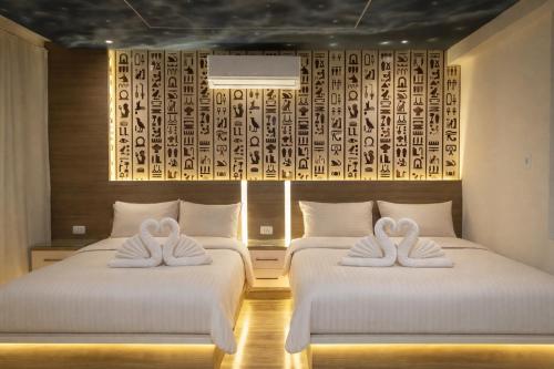 two beds with white towels on them in a room at Narmer Pyramids View in Cairo
