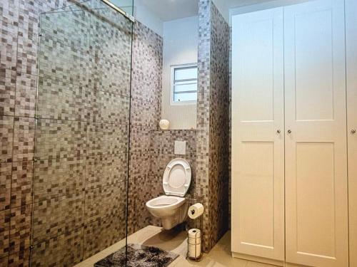 a bathroom with a toilet and a glass shower at Seabreez Hideaway Escape in Dawn Beach