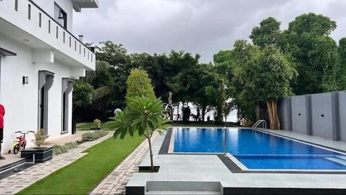 a swimming pool with a palm tree next to a building at Lisbon Lagoons in Negombo