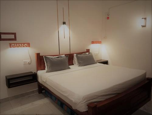 a bed in a room with two pillows on it at Lisbon Lagoons in Negombo