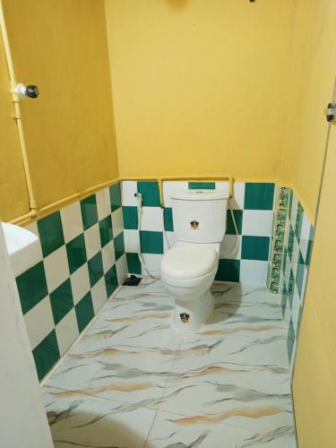 a bathroom with a toilet with a tiled floor at Riverview Adventure Resort in Kitulgala