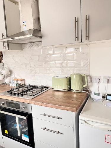 a kitchen with white cabinets and a stove top oven at Feel at Home away from Home in Nottingham