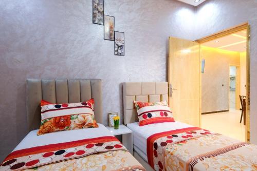 a bedroom with two beds and a mirror at Riad Bollywood-Royal Stay C in Benguerir