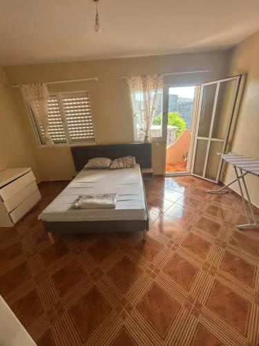 a bedroom with a bed and a wooden floor at Home Lenda in Tarrafal