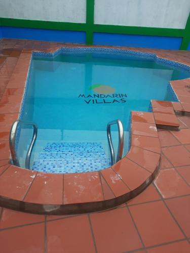 una piscina con una sedia al centro di Mandarin Villas a Mon Repos