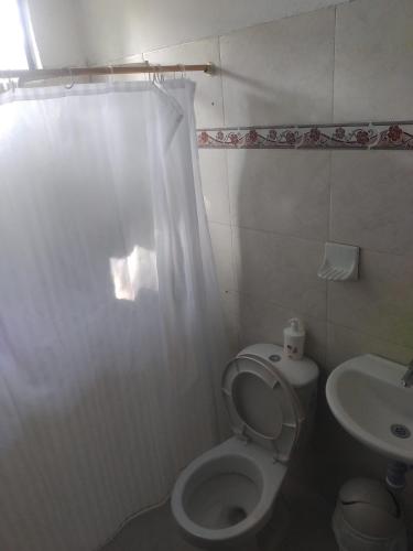 a bathroom with a toilet and a sink at Mágica Cabaña familiar cerca al mar in Coveñas