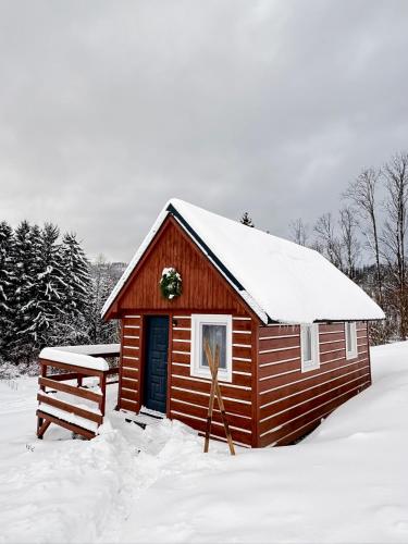 una piccola baita nella neve con una ghirlanda sopra di Apartmany Silver a Rokytnice nad Jizerou