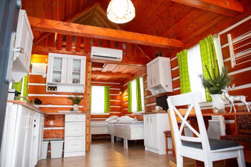 una cucina con pareti in legno e mobili bianchi in una cabina di Apartmany Silver a Rokytnice nad Jizerou
