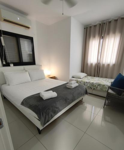 a bedroom with a large bed with towels on it at על הים in Nahariyya