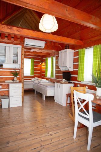 una cucina con mobili bianchi, tavolo e sedie di Apartmany Silver a Rokytnice nad Jizerou