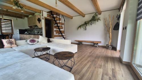 a living room with two white couches and a table at Chatki ŁoRawa w Jabłonce in Jabłonka