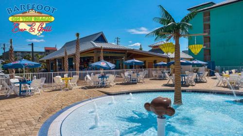 a swimming pool in a resort with a restaurant at The Barefoot Hotel in Panama City Beach