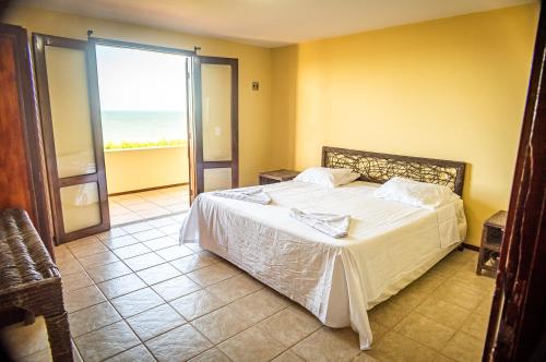 a bedroom with a bed with a view of the ocean at Aqua Villa by Garvetur in Beberibe