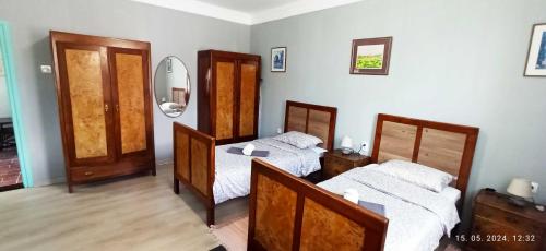 a bedroom with two beds and a mirror at Domaći Berek in Hlebine