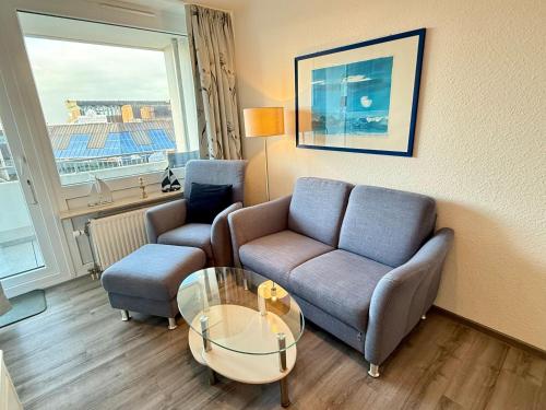 a living room with a couch and a glass table at Wiking, App 201A in Westerland