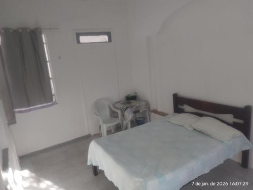 a bedroom with a bed and a table and a window at Nelson Pinheiro in São Luís