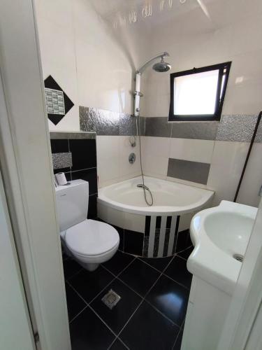 a bathroom with a white toilet and a sink at על הים in Nahariyya