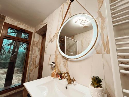 a bathroom with a sink and a mirror at Casuta Cerbului Colibita in Colibiţa