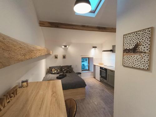 a bedroom with a bed and a table in a room at Agréable studio privé avec terrasse in Olliergues
