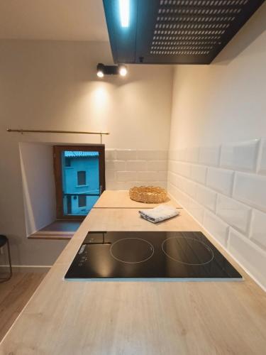 a kitchen with a stove and a counter top at Agréable studio privé avec terrasse in Olliergues