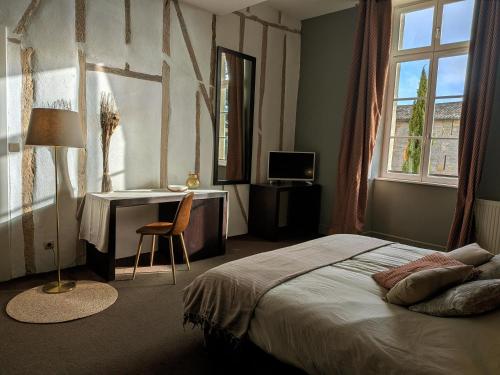 a bedroom with a bed and a desk and a window at Le Château de La Pomarède in La Pomarède