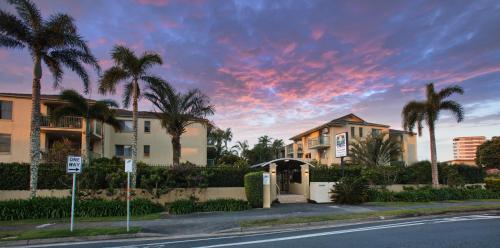 a house on a street with palm trees at Bila Vista Kirra Beachside Apartments in Gold Coast