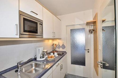 a kitchen with a sink and a microwave at Wiking, App 003 in Westerland
