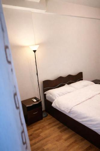 a bedroom with a bed and a lamp on a night stand at Warm Place In Old Town in Bucharest
