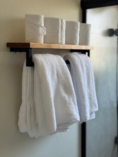 a group of white towels on a rack in a bathroom at Tiny House Campeche - Vista do Lampião in Florianópolis