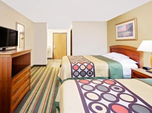 a hotel room with two beds and a flat screen tv at Super 8 by Wyndham Mt. Pleasant in Mount Pleasant