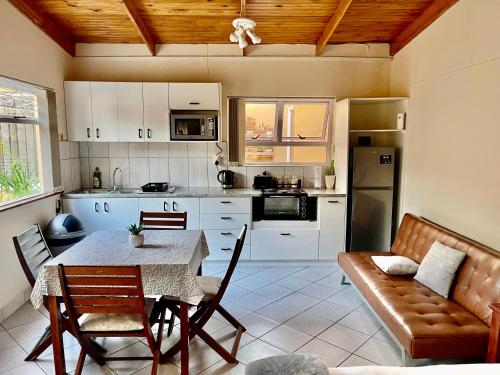 cocina y comedor con mesa y sofá en Lyn's Self Catering, en Swakopmund