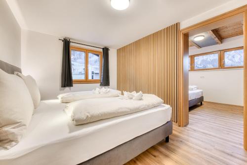 two beds in a room with white walls and wooden floors at Ferienwohnung Gipfelstube in Brand
