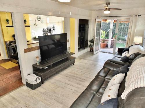 a living room with a couch and a flat screen tv at Eastside Garden Hideaway For 4 Perfect Location for World Cup Attendees in Long Beach