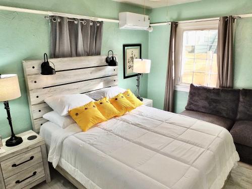 a bedroom with a large white bed with yellow pillows at Eastside Garden Hideaway For 4 Perfect Location for World Cup Attendees in Long Beach