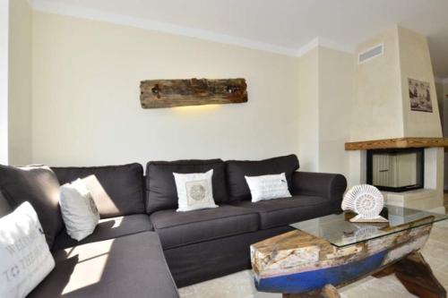 a living room with a black couch and a table at Ferienhaus Litj Stig in Westerland