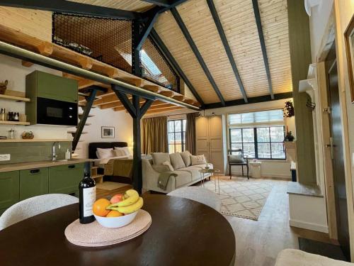 a kitchen and living room with a table with a bowl of fruit at Country Charm in Râşnov