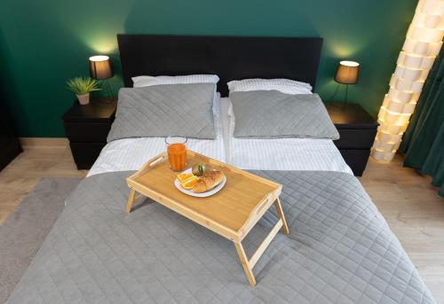 a table with a plate of food on a bed at Luxus Apartament Róża in Gdynia
