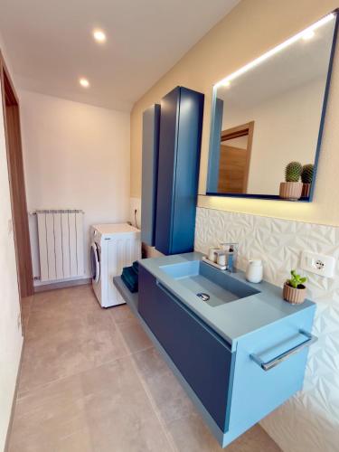 a bathroom with a blue sink and a mirror at Casa Alpea in Villadossola