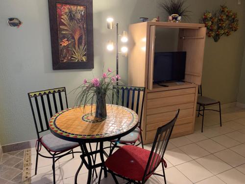 a dining room table with a vase of flowers on it at Harbour Beach Resort in Daytona Beach