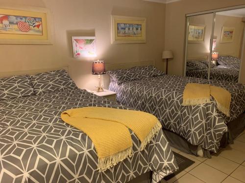 a hotel room with two beds and a mirror at Harbour Beach Resort in Daytona Beach