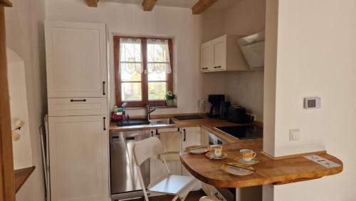 a kitchen with a wooden table and a white refrigerator at Sethmacher Stube in Bad Gottleuba