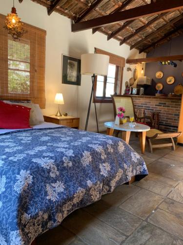 a bedroom with a large bed and a table at Villa Violeta in Petrópolis